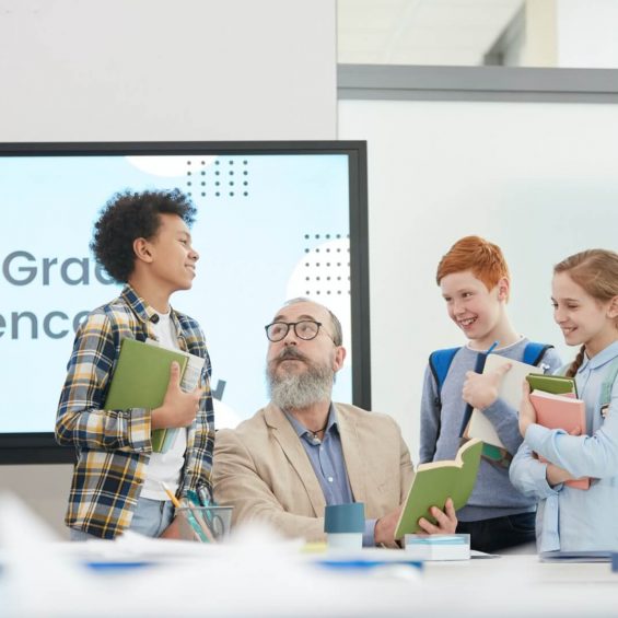 group-of-kids-talking-to-teacher-in-school.jpg